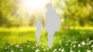Silhouette einer Frau und eines Kindes vor einer Blumenwiese