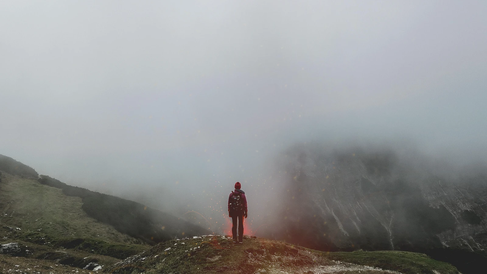 Mann auf einer Klippe mit Neben und Schatten und angedeuteten Flammen